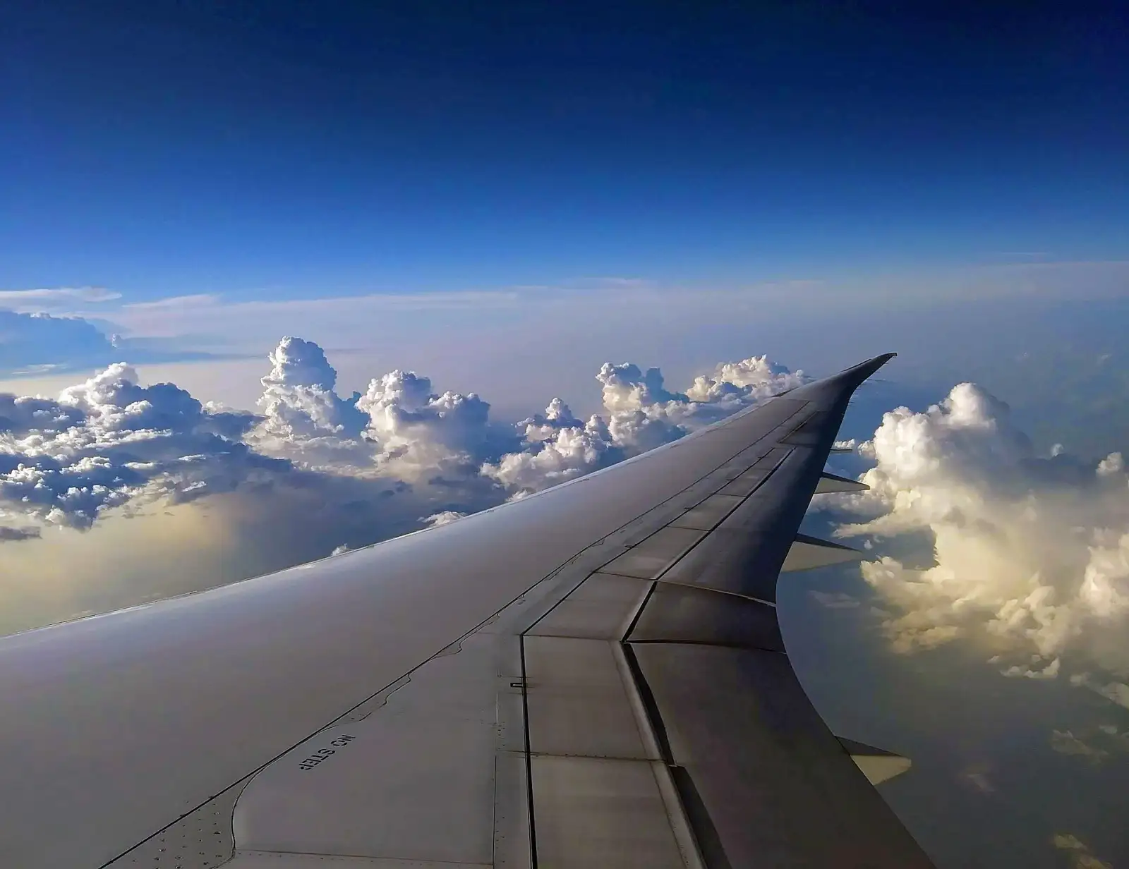 An aircraft wing above the clouds